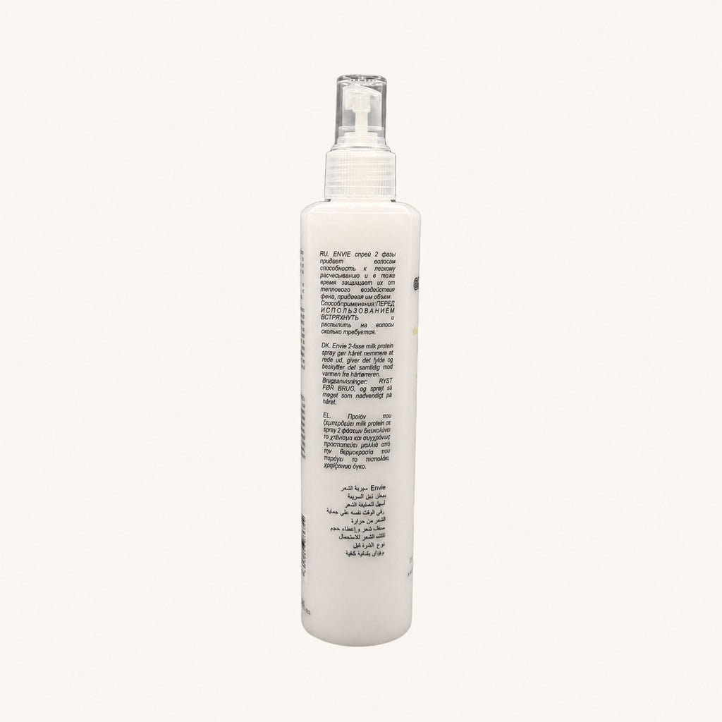 Envie Milk Districante Bifasico — flacone spray su fondo crema