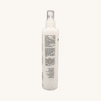 Envie Milk Districante Bifasico — flacone spray su fondo crema