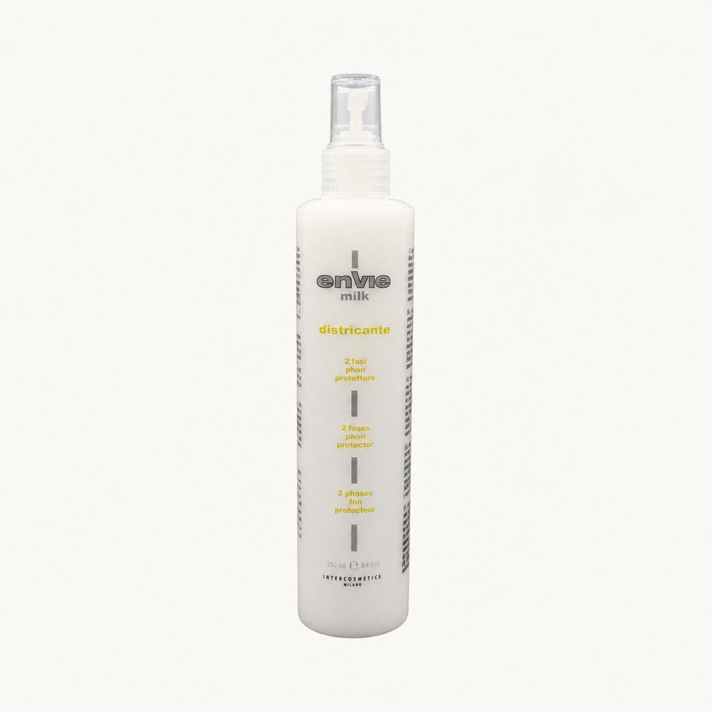 Envie Milk Districante Bifasico — flacone spray su fondo crema
